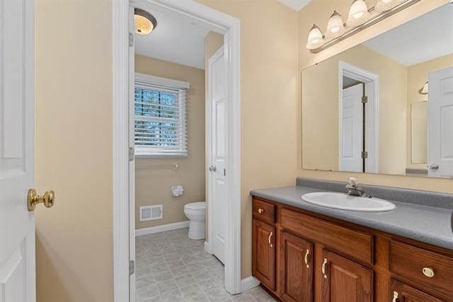 bathroom featuring visible vents, baseboards, toilet, and vanity