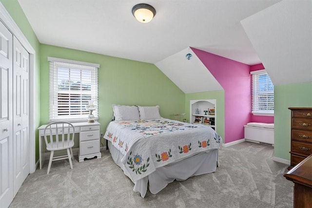 carpeted bedroom featuring a closet, baseboards, and vaulted ceiling
