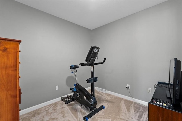 exercise area with baseboards and carpet flooring