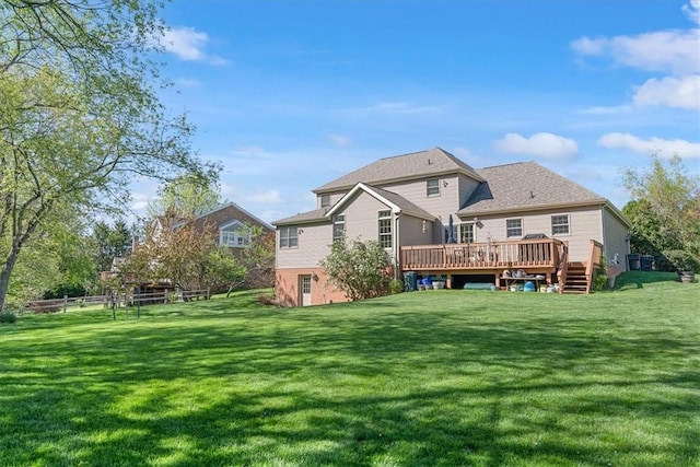 back of house with fence, a yard, and a deck