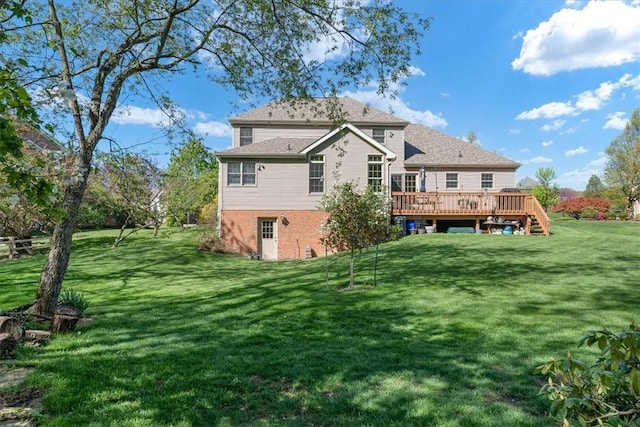 rear view of house with a wooden deck and a yard