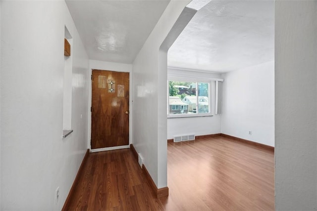 entryway featuring baseboards, visible vents, and wood finished floors