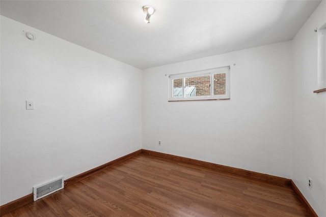unfurnished room with visible vents, baseboards, and wood finished floors