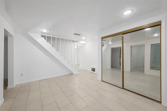 interior space with stairway, baseboards, and visible vents
