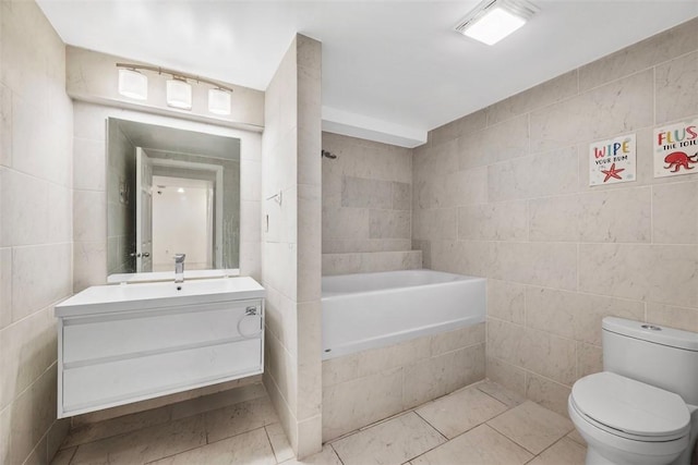 full bath with vanity, toilet, tile walls, tiled shower / bath, and tile patterned floors