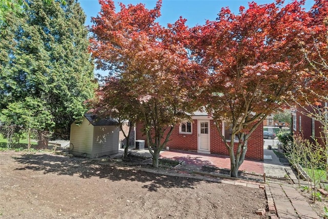 exterior space featuring fence, a storage unit, an outbuilding, and cooling unit