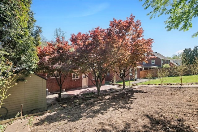 exterior space with fence, a patio, and brick siding