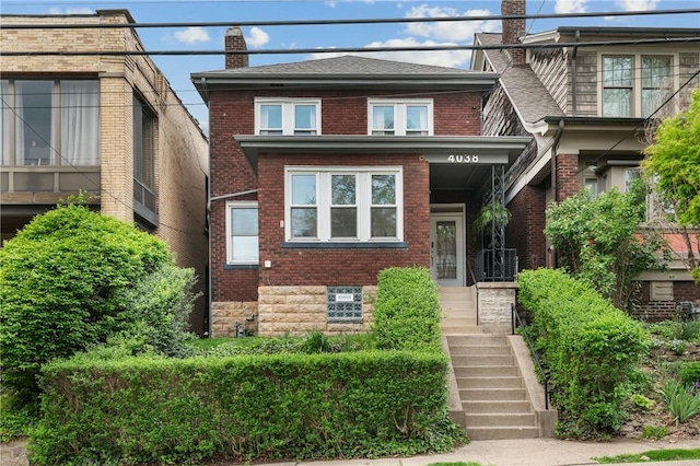 view of front facade with brick siding and a chimney