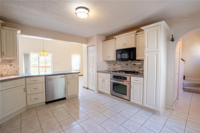 1437 Yorktown Dr, Cecil, PA 15055 - kitchen with arched walkways, light tile patterned flooring, tasteful backsplash, and stainless steel appliances