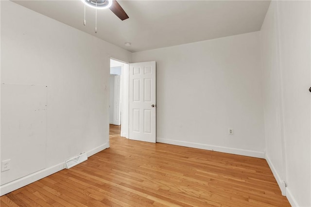spare room featuring ceiling fan, visible vents, baseboards, and light wood-style floors