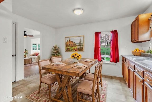 dining space with light floors and ceiling fan