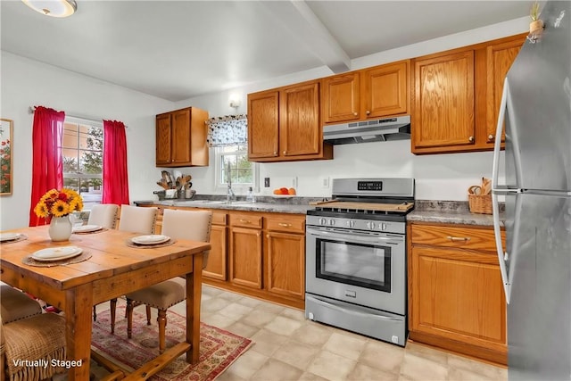 kitchen with under cabinet range hood, a wealth of natural light, appliances with stainless steel finishes, and brown cabinets