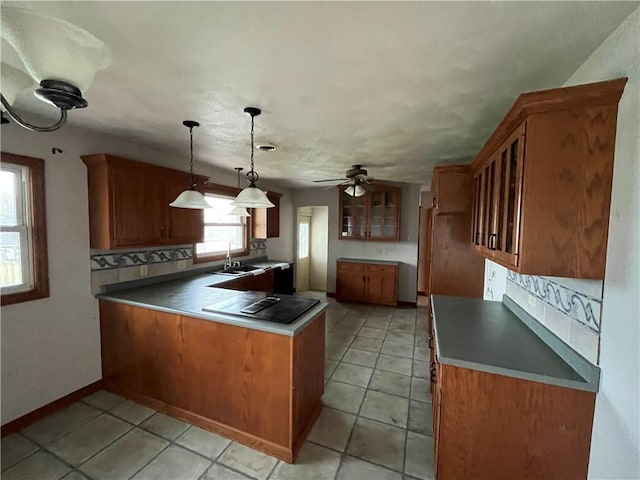246 Anderson Ave, Indiana Boro Ind, PA 15701 - kitchen featuring a peninsula, glass insert cabinets, brown cabinets, tasteful backsplash, and a sink