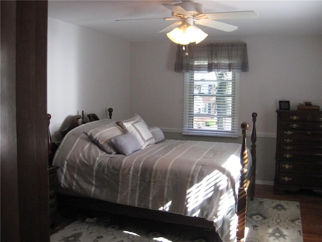 bedroom with baseboards, ceiling fan, and wood finished floors