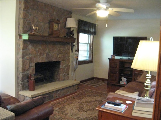 living room featuring a stone fireplace and a ceiling fan