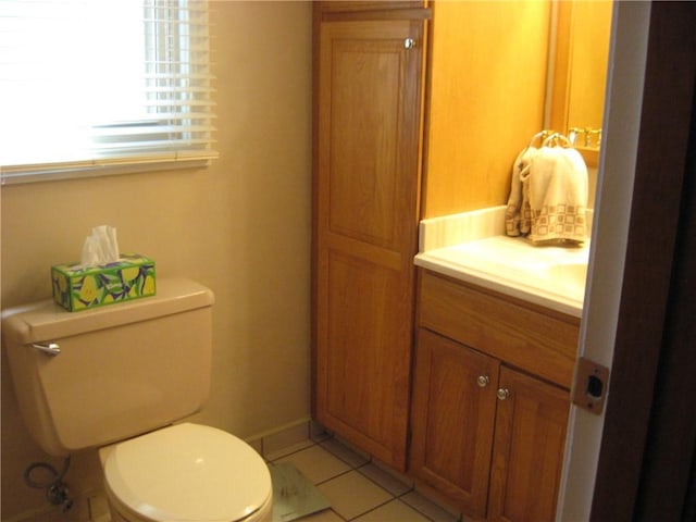 half bathroom featuring toilet, tile patterned flooring, and vanity