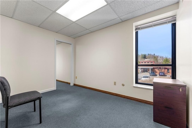 unfurnished room with baseboards, carpet, a drop ceiling, and a wealth of natural light