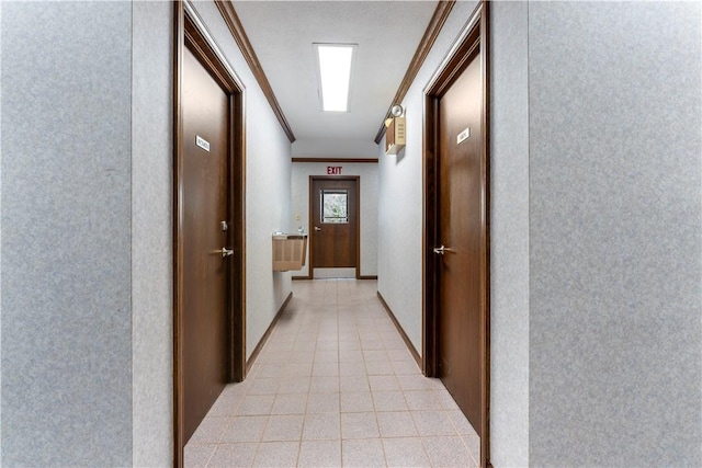 hallway with crown molding and light tile patterned floors