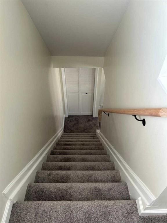 staircase with baseboards and carpet flooring