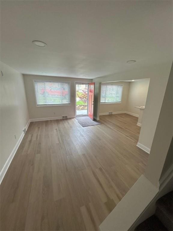 unfurnished living room with baseboards and wood finished floors