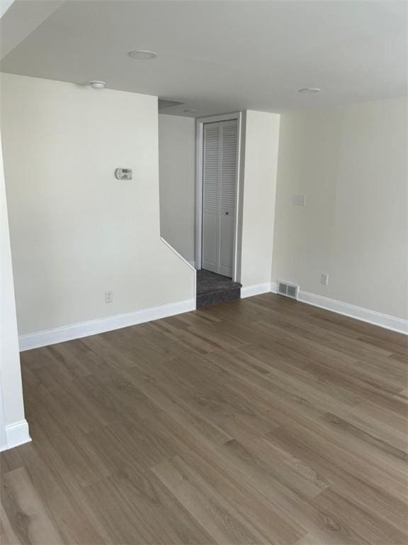 spare room featuring baseboards, visible vents, and wood finished floors