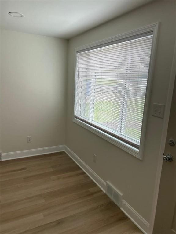 unfurnished room with visible vents, light wood-style flooring, and baseboards