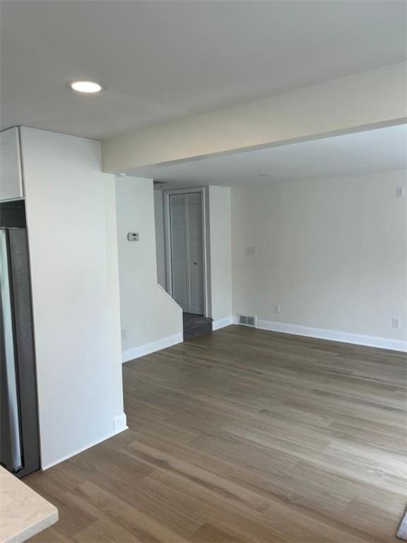 empty room featuring baseboards, recessed lighting, wood finished floors, and visible vents