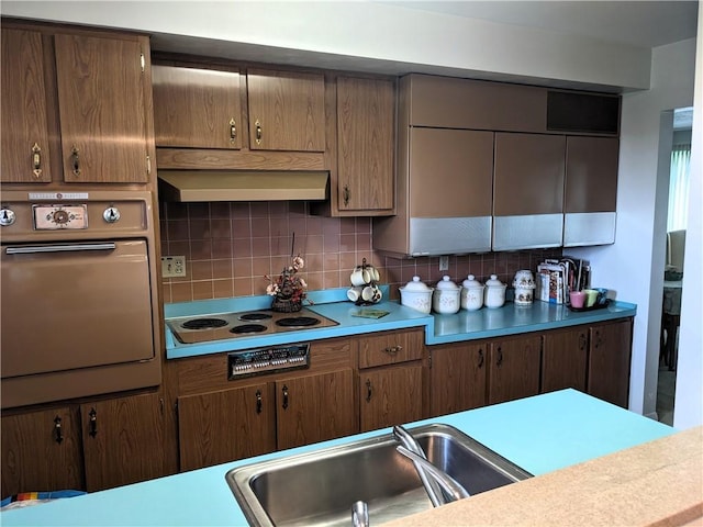 211 Wainwright Dr, Mckeesport, PA 15132 - kitchen featuring oven, ventilation hood, stovetop, tasteful backsplash, and a sink