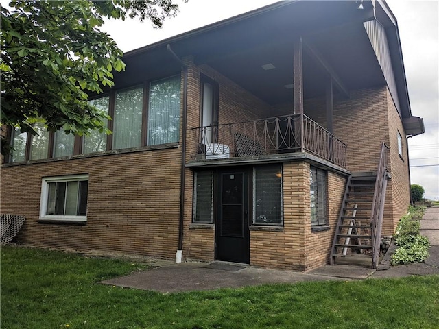 211 Wainwright Dr, Mckeesport, PA 15132 - rear view of property featuring a lawn, stairs, brick siding, and a balcony