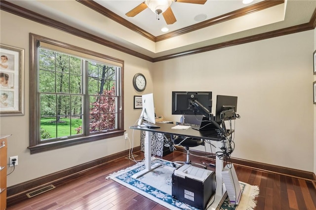 office featuring baseboards, wood-type flooring, a tray ceiling, and visible vents