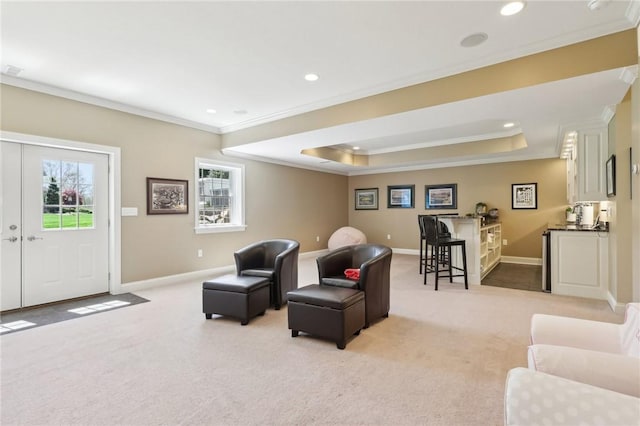living room with light colored carpet, ornamental molding, a raised ceiling, and recessed lighting