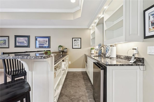 bar featuring refrigerator, baseboards, a raised ceiling, a sink, and wet bar