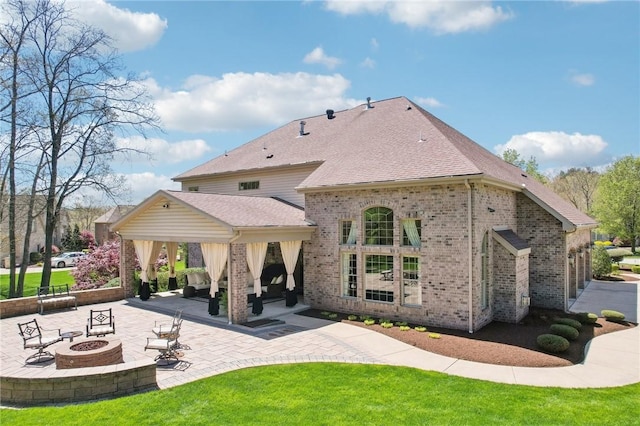 back of house featuring a patio area, brick siding, a gazebo, a yard, and a fire pit