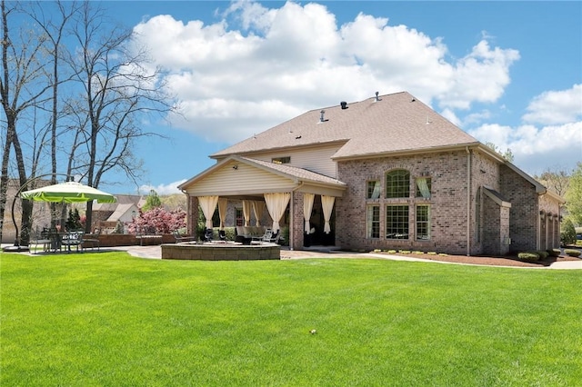 rear view of house with a yard, a patio area, and brick siding