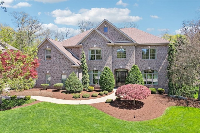 view of front of property featuring a front lawn and brick siding