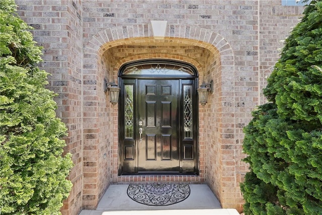 view of exterior entry with brick siding