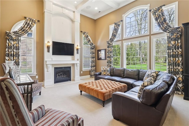 living room with carpet floors, a high ceiling, a large fireplace, and beam ceiling