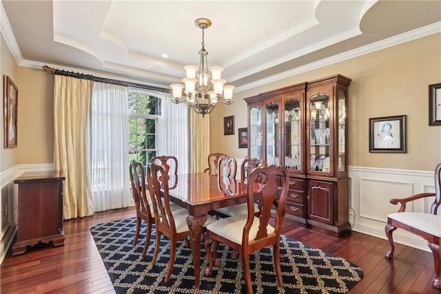 dining space featuring a tray ceiling, dark wood-type flooring, and a chandelier