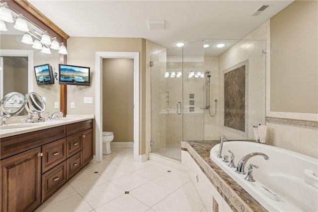 bathroom with a garden tub, double vanity, toilet, a sink, and a stall shower