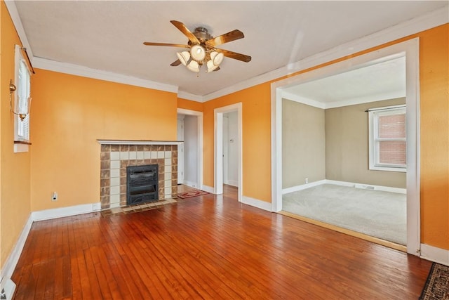 unfurnished living room with baseboards, a ceiling fan, hardwood / wood-style floors, and a tile fireplace