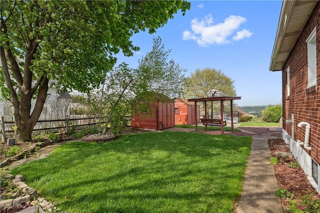 view of yard with an outdoor structure, fence, and a shed
