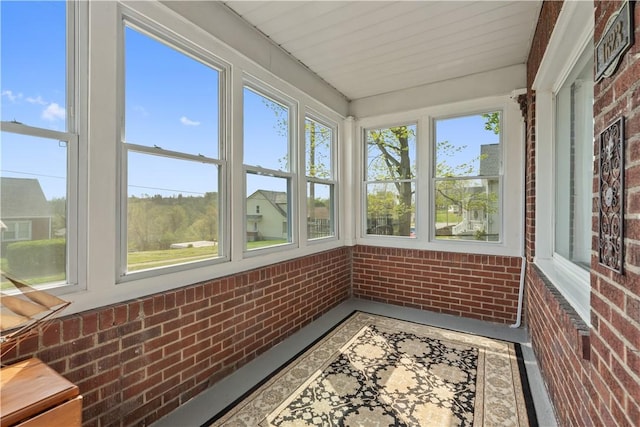 unfurnished sunroom featuring brick wall