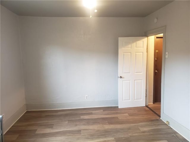 empty room featuring baseboards and wood finished floors