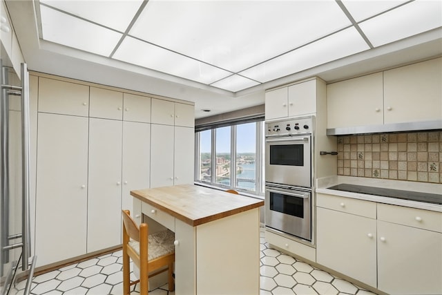 111 Grandview Ave Unit 801, Mt Washington, PA 15211 - kitchen with double oven, black electric cooktop, wooden counters, light floors, and backsplash