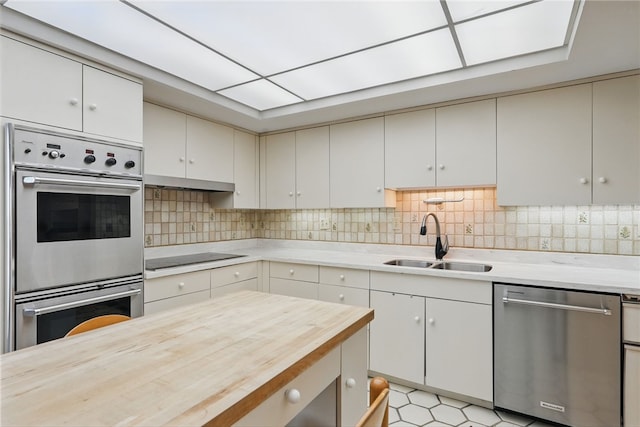 111 Grandview Ave Unit 801, Mt Washington, PA 15211 - kitchen with backsplash, a sink, under cabinet range hood, stainless steel appliances, and butcher block countertops