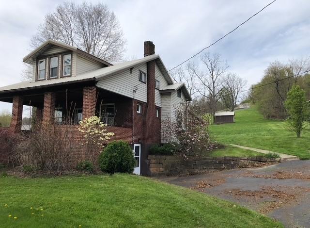 1075 E National Pike, South Strabane, PA 15301 - view of side of property featuring a lawn, brick siding, and a chimney