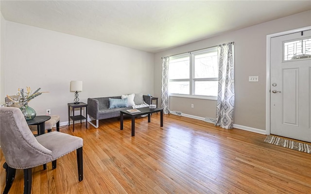 interior space featuring baseboards, light wood finished floors, a healthy amount of sunlight, and visible vents