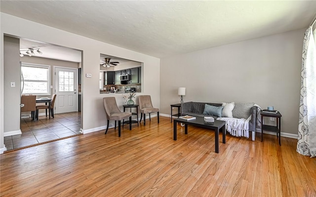 living room with baseboards and light wood-style flooring
