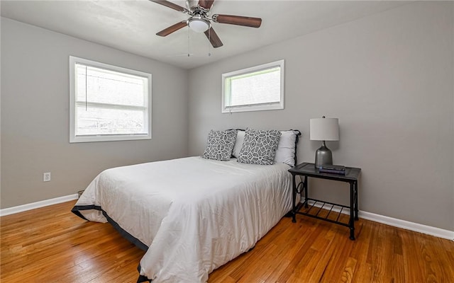 bedroom with baseboards, ceiling fan, and wood finished floors