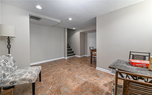 sitting room featuring visible vents, baseboards, stairway, recessed lighting, and stone finish flooring
